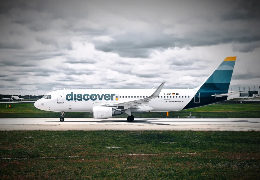 Discover Airlines Airbus in side profile taxiing at Munich beneath a heavy grey sky.
