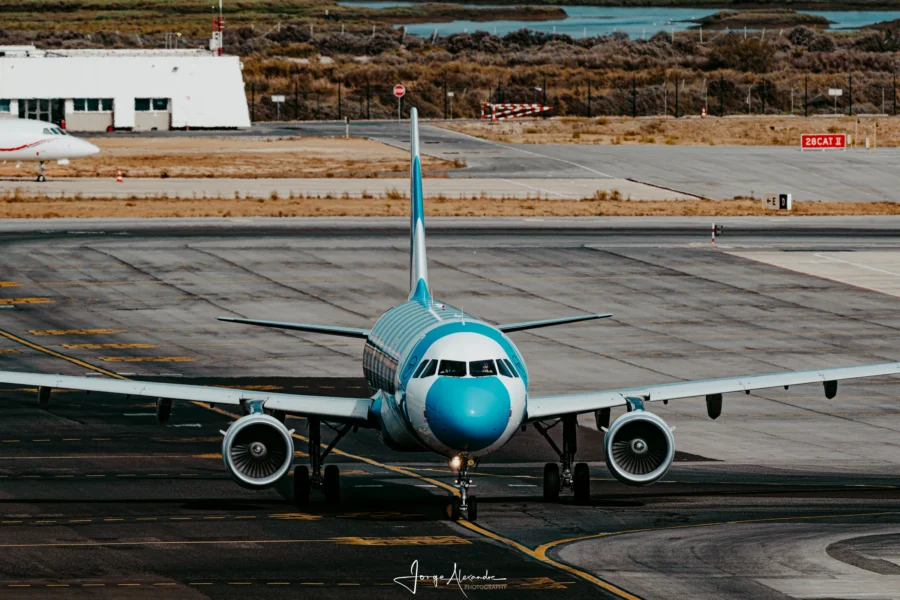 Condor Airbus in blue and white striped livery taxiing head-on towards the camera.