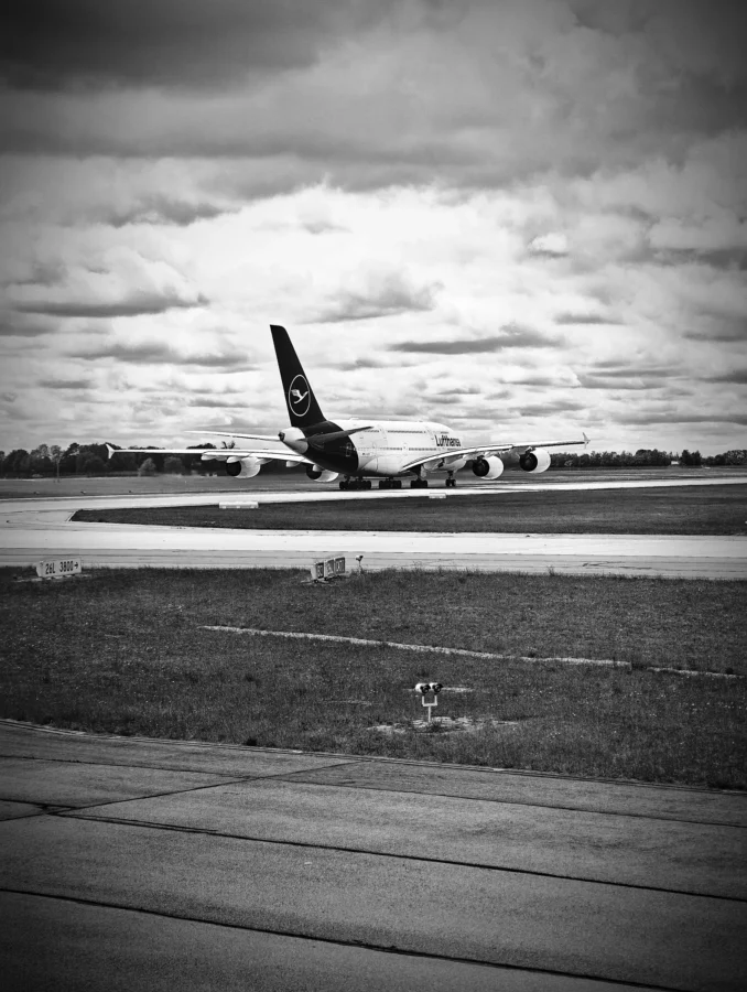 Black and white photograph of a Lufthansa Airbus A380 on the runway at Munich beneath dramatic cloud.